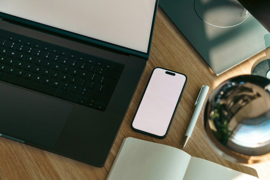 Namų vartotojo darbo vieta su telefonu ir nešiojamuoju kompiuteriu, prijungtais prie debesinės saugyklos