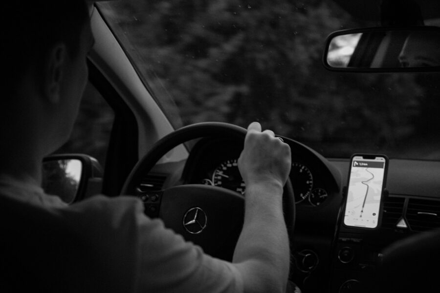 Išmanusis telefonas su veikiančia navigacijos programėle pritvirtintas prie automobilio panelės