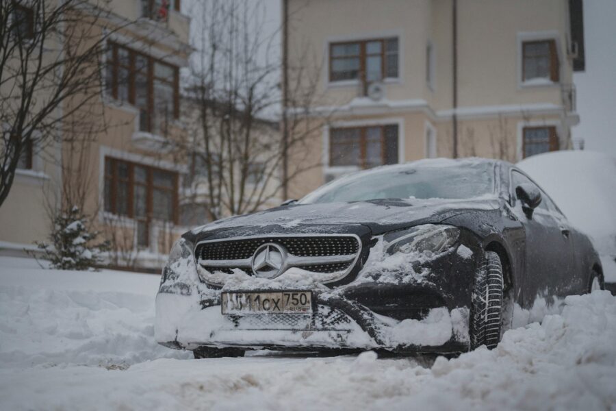 Šiuolaikinio automobilio salonas žiemą, vairuotojas tik ką užvedė variklį