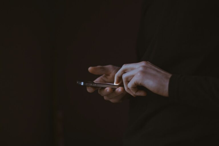 Telefono ekrane rodomi nauji el. pašto pranešimai, iliustruojantys nuolatinius darbo nutraukimus